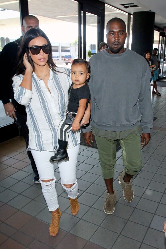 Voyage en famille ! Kim Kardashian, son mari Kanye West et leur fille North prennent un vol à l'aéroport LAX de Los Angeles. Le 1er septembre 2014.