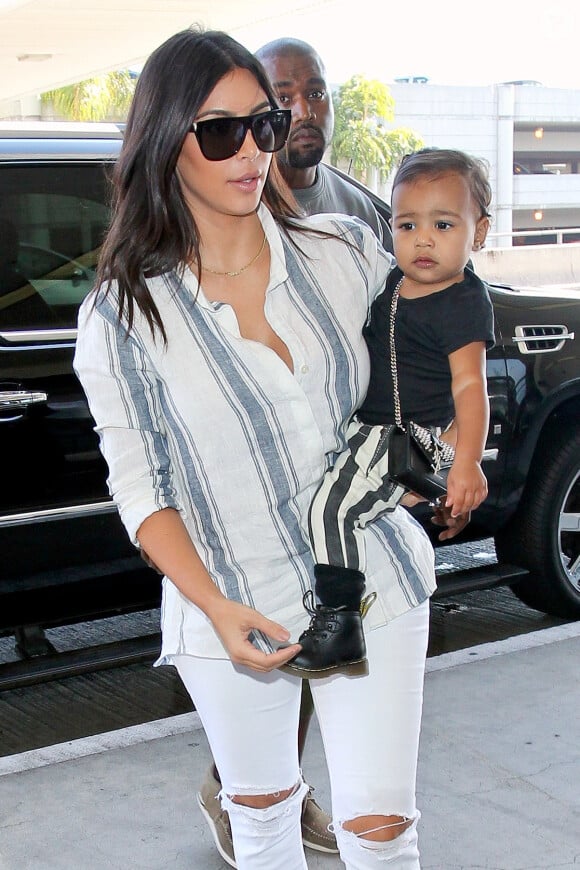 Kim Kardashian, son mari Kanye West et leur fille North prennent un vol à l'aéroport de Los Angeles. Le 1er septembre 2014.