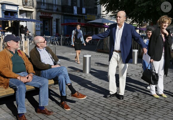 Alain Juppé se promène avec sa femme Isabelle dans les rues de Bordeaux, le 27 septembre 2014.