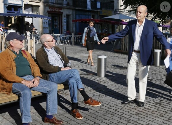 Alain Juppé se promène avec sa femme Isabelle dans les rues de Bordeaux, le 27 septembre 2014.