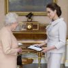 Angelina Jolie se voit remettre l'insigne de l'Honorary Dame Grand Cross of the Most Distinguished Order of St Michael and St George par la reine Elizabeth II à Buckingham Palace, Londres, le 10 octobre 2014.