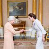 Angelina Jolie se voit remettre l'insigne de l'Honorary Dame Grand Cross of the Most Distinguished Order of St Michael and St George par la reine Elizabeth II à Buckingham Palace, Londres, le 10 octobre 2014.