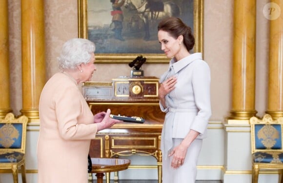 Angelina Jolie, honorée, reçoit le titre de Dame grand-croix de l'ordre de St Michael et St George, la plus haute distinction civile du Royaume-Uni, au palais de Buckingham à Londres, le 10 octobre 2014