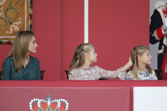 La princesse Leonor intriguée par le coiffure de sa soeur Sofia... Le roi Felipe VI d'Espagne, entouré de sa femme la reine Letizia et de leurs filles Leonor, princesse des Asturies, et Sofia, présidait pour la première fois de son règne les célébrations de la Fête nationale espagnole, le 12 octobre 2014 à Madrid.