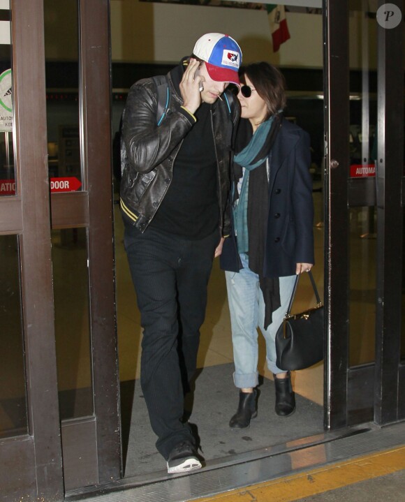 Exclusif - Ashton Kutcher et sa fiancée Mila Kunis, enceinte, arrivent à Los Angeles en provenance de l'Iowa où ils ont rendu visite aux parents d'Ashton, le 30 mars 2014.