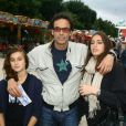 Anthony Delon et ses filles Loup et Liv lors de l'inauguration de la fête foraine des Tuileries à Paris le 28 juin 2013