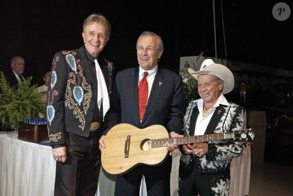 Le Secrétaire à la défense Donald H. Rumsfeld entouré des légendes de la country Bill Anderson et Little Jimmy Dickens au Grand Ole Opry Houses de Nashville le 23 avril 2005