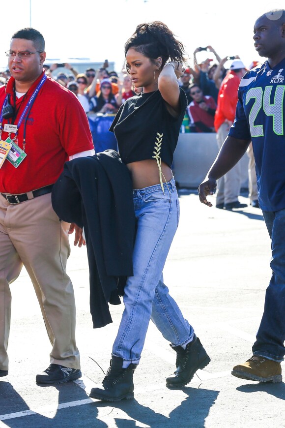 Rihanna arrive au stade de l'université de Phoenix, habillée d'un top noir Toga Archives, d'un jean large et de bottines noires Timberland. Phoenix, le 1er février 2015.