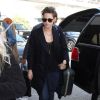 Kristen Stewart prend un vol à l'aéroport de Los Angeles avec sa présumée compagne Alicia Cargile, habillée d'un long manteau marine, d'un jean et de baskets Vans. Un sac Chanel et des lunettes de soleil accessoirisent sa tenue. Le 4 février 2015.