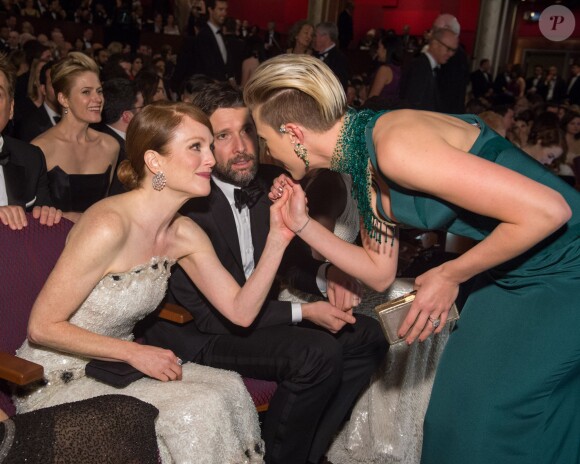 Scarlett Johansson glisse un petit mot à Julianne Moore lors de la 87e cérémonie des Oscars à Los Angeles, le 22 février 2015. 