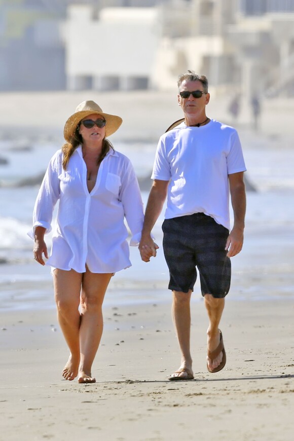 Exclusif - Pierce Brosnan et sa femme Keely Smith promènent leur chien sur une plage de Malibu le 8 mars 2015.