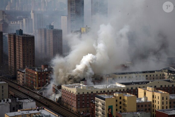 Exclusif - Deux immeubles se sont effondrés après une explosion due à une fuite de gaz, mercredi 12 mars 2014 vers 9h30 (14h30 heure française) à New York dans le quartier de East Harlem (Manhattan). L'explosion puis l'effondrement, qui ont provoqué un important incendie et un gigantesque nuage de fumée, se sont produits au croisement de la 116e rue et de Park Avenue. Le dernier bilan rapporté par les pompiers de New York et plusieurs médias américains fait désormais état d'au moins deux morts et 22 blessés mais plusieurs personnes seraient encore être coincées dans les décombres.