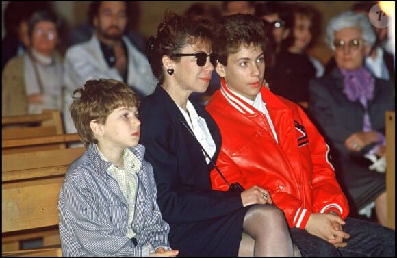 Véronique Colucci avec ses fils Marius et Romain, le jour de l'enterrement de Coluche, le 24 juin 1986