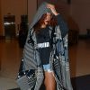 Rihanna, le visage partiellement caché par ses cheveux roux et la capuche de son poncho, arrive à l'aéroport LAX de Los Angeles. Le 28 avril 2015.