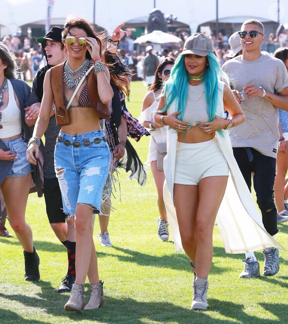 Kendall Jenner et Kylie Jenner, ravissante dans sa longue veste Nomia, un crop-top Brandy Melville, un mini-short blanc American Apparel et des bottines Timberland, assistent au 1er jour du festival de Coachella. Le 10 avril 2015.