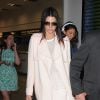 Kendall Jenner arrive à l'aéroport de Nice, tout de blanc vêtue, chaussée de sandales Sophia Webster (modèle Delphine) et tenant un sac nude Marc Jacobs (modèle Incognito). Le 19 mai 2015.