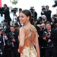 Irina Shayk, exquise en robe dorée Versace, monte les marches du Palais des Festivals avant la projection du film en compétition "Sicario à Cannes, le 19 mai 2015.