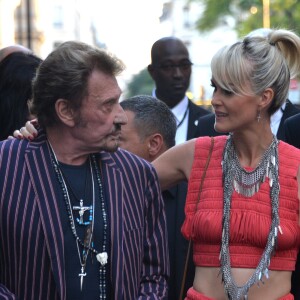 Johnny Hallyday et sa femme Laeticia Hallyday arrivent au défilé Saint Laurent homme collection printemps-été 2016 au Carreau du Temple lors de la Fashion Week à Paris, le 28 juin 2015.