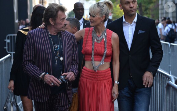 Johnny Hallyday et sa femme Laeticia Hallyday arrivent au défilé Saint Laurent homme collection printemps-été 2016 au Carreau du Temple lors de la Fashion Week à Paris, le 28 juin 2015.
