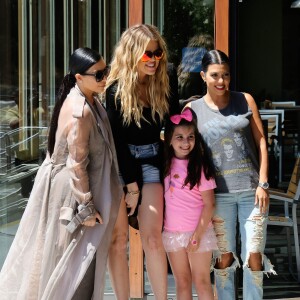 Les soeurs Kim, Khloé et Kourtney Kardashian, sollicitée par une jeune admiratrice, posent pour une photo souvenir devant le restaurant Hugo's à Ahoura Hills, le 14 juillet 2015.