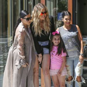 Les soeurs Kim, Khloé et Kourtney Kardashian, sollicitée par une jeune admiratrice, posent pour une photo souvenir devant le restaurant Hugo's à Ahoura Hills, le 14 juillet 2015.