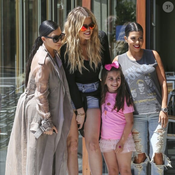 Les soeurs Kim, Khloé et Kourtney Kardashian, sollicitée par une jeune admiratrice, posent pour une photo souvenir devant le restaurant Hugo's à Ahoura Hills, le 14 juillet 2015.