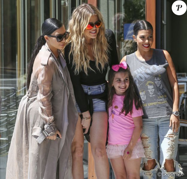 Les soeurs Kim, Khloé et Kourtney Kardashian, sollicitée par une jeune admiratrice, posent pour une photo souvenir devant le restaurant Hugo's à Ahoura Hills, le 14 juillet 2015.