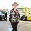 Rosie Huntington-Whiteley arrive à l'aéroport LAX de Los Angeles, habillée d'une veste noire brodée de fleurs, d'un t-shirt noir, d'un jean Paige et de sandales noires. Un chapeau Maison Michel et un sac Balenciaga (modèle Papier A4) accessoirisent sa tenue. Le 23 juillet 2015.