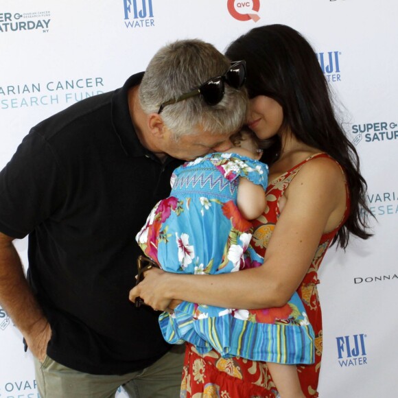 Alec Baldwin, sa femme Hilaria Thomas et leur fille Carmen Baldwin complices et câlins à l'événement caritatif "Ovarian Cancer Research Fund's Super Saturday" à Water Mill le 25 juillet 2015.