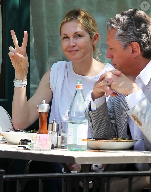 Exclusif - Kelly Rutherford fait un signe "peace" aux photographes alors qu'elle déjeune en terrasse du restaurant Sant Ambroeus avec un ami à New York, le 5 mai 2015. 