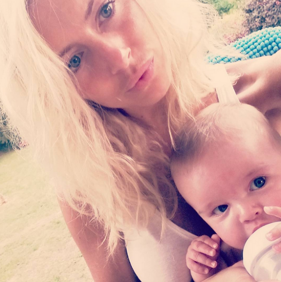 Stéphanie Clerbois (Secret Story 4) donne le biberon à son bébé Lyam. Juillet 2015.