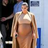 Kim Kardashian, enceinte et habillée d'un manteau marron, d'un body Maison Margiela, d'une jupe Wolford et de sandales Hermès, quitte un studio de tournage à Van Nuys. Los Angeles, le 31 août 2015.