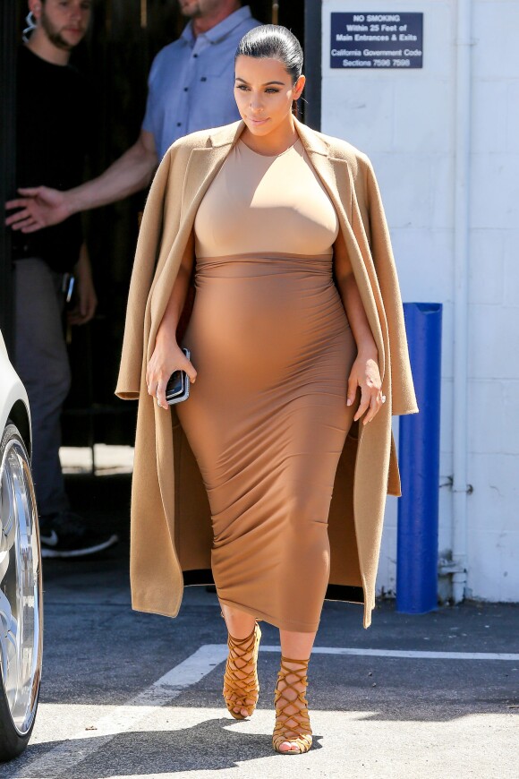 Kim Kardashian, enceinte et habillée d'un manteau marron, d'un body Maison Margiela, d'une jupe Wolford et de sandales Hermès, quitte un studio de tournage à Van Nuys. Los Angeles, le 31 août 2015.