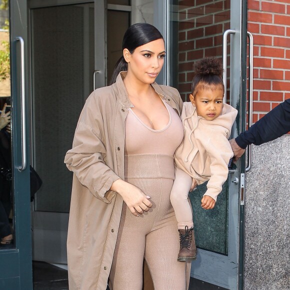 Kim Kardashian et sa fille North, toutes de beiges vêtues, quittent leur appartement à SoHo et se rendent au Skylight Modern à Chelsea, pour assister à la présentation de la collection Yeezy Season 2 de Kanye West. New York, le 16 septembre 2015.