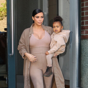 Kim Kardashian et sa fille North, toutes de beiges vêtues, quittent leur appartement à SoHo et se rendent au Skylight Modern à Chelsea, pour assister à la présentation de la collection Yeezy Season 2 de Kanye West. New York, le 16 septembre 2015.