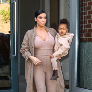 Kim Kardashian et sa fille North, toutes de beiges vêtues, quittent leur appartement à SoHo et se rendent au Skylight Modern à Chelsea, pour assister à la présentation de la collection Yeezy Season 2 de Kanye West. New York, le 16 septembre 2015.