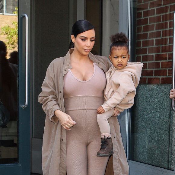 Kim Kardashian et sa fille North, toutes de beiges vêtues, quittent leur appartement à SoHo et se rendent au Skylight Modern à Chelsea, pour assister à la présentation de la collection Yeezy Season 2 de Kanye West. New York, le 16 septembre 2015.