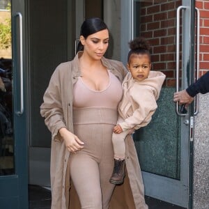 Kim Kardashian et sa fille North, toutes de beiges vêtues, quittent leur appartement à SoHo et se rendent au Skylight Modern à Chelsea, pour assister à la présentation de la collection Yeezy Season 2 de Kanye West. New York, le 16 septembre 2015.