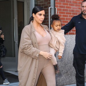 Kim Kardashian et sa fille North, toutes de beiges vêtues, quittent leur appartement à SoHo et se rendent au Skylight Modern à Chelsea, pour assister à la présentation de la collection Yeezy Season 2 de Kanye West. New York, le 16 septembre 2015.