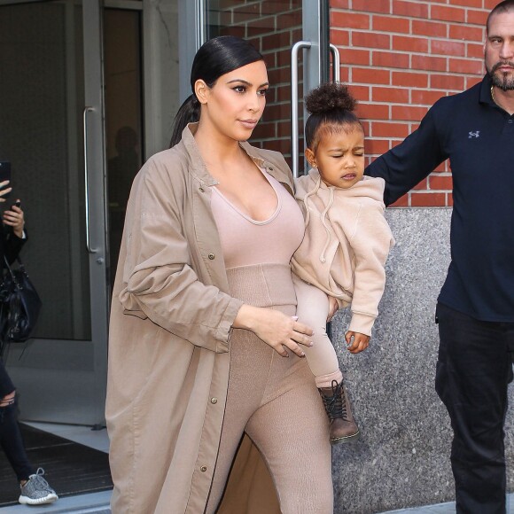 Kim Kardashian et sa fille North, toutes de beiges vêtues, quittent leur appartement à SoHo et se rendent au Skylight Modern à Chelsea, pour assister à la présentation de la collection Yeezy Season 2 de Kanye West. New York, le 16 septembre 2015.