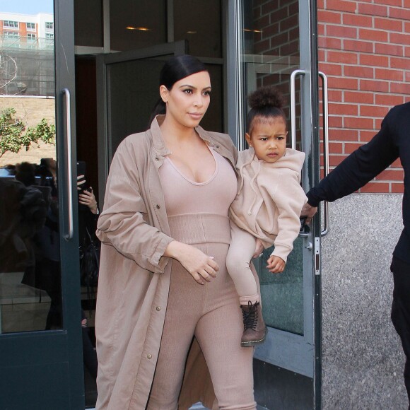 Kim Kardashian et sa fille North, toutes de beiges vêtues, quittent leur appartement à SoHo et se rendent au Skylight Modern à Chelsea, pour assister à la présentation de la collection Yeezy Season 2 de Kanye West. New York, le 16 septembre 2015.