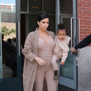 Kim Kardashian et sa fille North, toutes de beiges vêtues, quittent leur appartement à SoHo et se rendent au Skylight Modern à Chelsea, pour assister à la présentation de la collection Yeezy Season 2 de Kanye West. New York, le 16 septembre 2015.