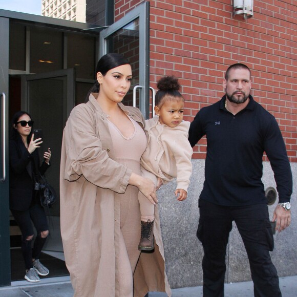 Kim Kardashian et sa fille North, toutes de beiges vêtues, quittent leur appartement à SoHo et se rendent au Skylight Modern à Chelsea, pour assister à la présentation de la collection Yeezy Season 2 de Kanye West. New York, le 16 septembre 2015.