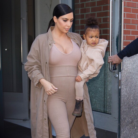 Kim Kardashian et sa fille North, toutes de beiges vêtues, quittent leur appartement à SoHo et se rendent au Skylight Modern à Chelsea, pour assister à la présentation de la collection Yeezy Season 2 de Kanye West. New York, le 16 septembre 2015.