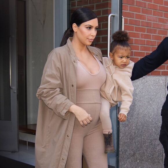 Kim Kardashian et sa fille North, toutes de beiges vêtues, quittent leur appartement à SoHo et se rendent au Skylight Modern à Chelsea, pour assister à la présentation de la collection Yeezy Season 2 de Kanye West. New York, le 16 septembre 2015.