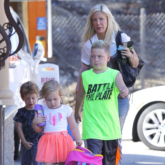 Exclusif - Tori Spelling se promène avec un inconnu et avec ses enfants Liam, Stella, Finn et Hattie dans les rues de Tarzana. Le petit Liam est allé chez le coiffeur «Floyd Barbershop» et la petite famille est allée ensuite diner dans un restaurant mexicain. Tori porte toujours son bandage. L'actrice américaine de 42 ans a décidé de porter plainte contre la chaîne de restaurants Benihana, qu'elle estime responsable de sa vilaine brûlure au bras droit. Le 6 septembre 2015