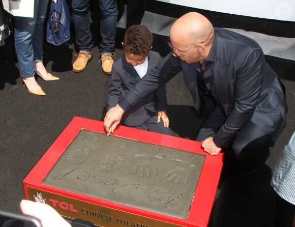 Vin Diesel laisse ses empreintes dans le ciment hollywoodien au TCL Chinese Theater à Hollywood, le 1er avril 2015, avec son fils Vincent Sinclair