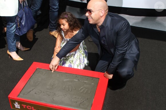 Vin Diesel laisse ses empreintes dans le ciment hollywoodien au TCL Chinese Theater à Hollywood, le 1er avril 2015, avec sa fille Hania Riley