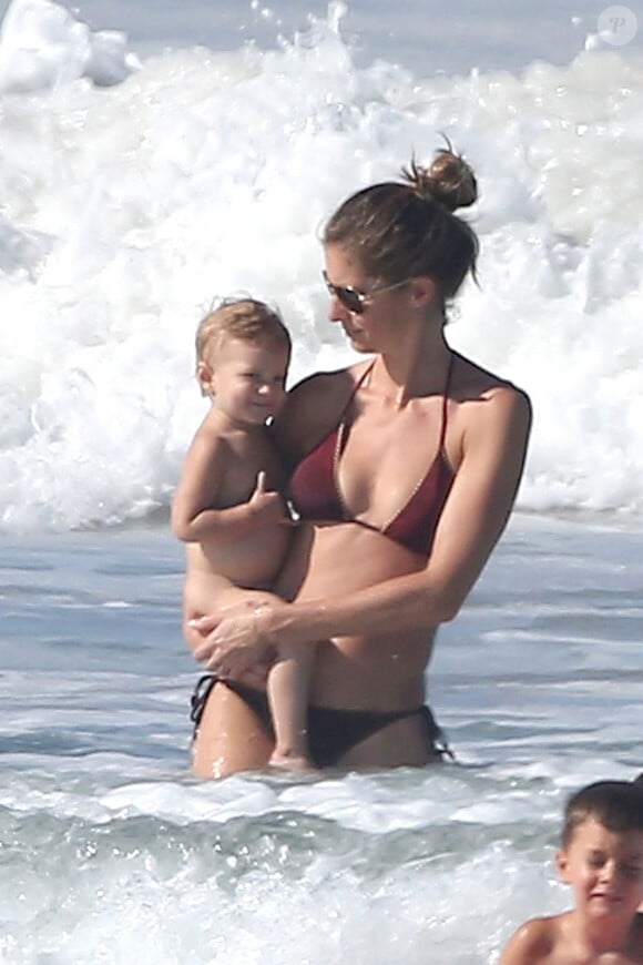 Exclusif - Gisele Bundchen et Tom Brady et leurs enfants en vacances au Costa Rica le 15 mars 2014. Tom donne sa première leçon de surf à son fils Benjamin. Exclusive - No Web No Blog - For Germany call for price - Please hide children's face prior to the publication - Gisele Bundchen holding Vivian watches Tom Brady giving their son Benjamin his very first surfing lesson while vacationing in Costa Rica on March 15th 2014. Gisele cheered as Benjamin caught his first wave while Vivian seemed to be giving the "hang loose" sign.15/03/2014 -