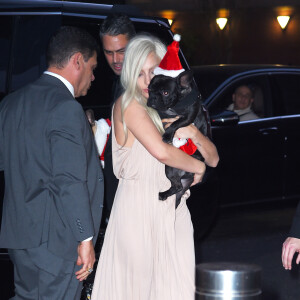 Lady Gaga et son fiancé Taylor Kinney à une soirée à New York avec un chien déguisé en père noël le 11 décembre 2015.